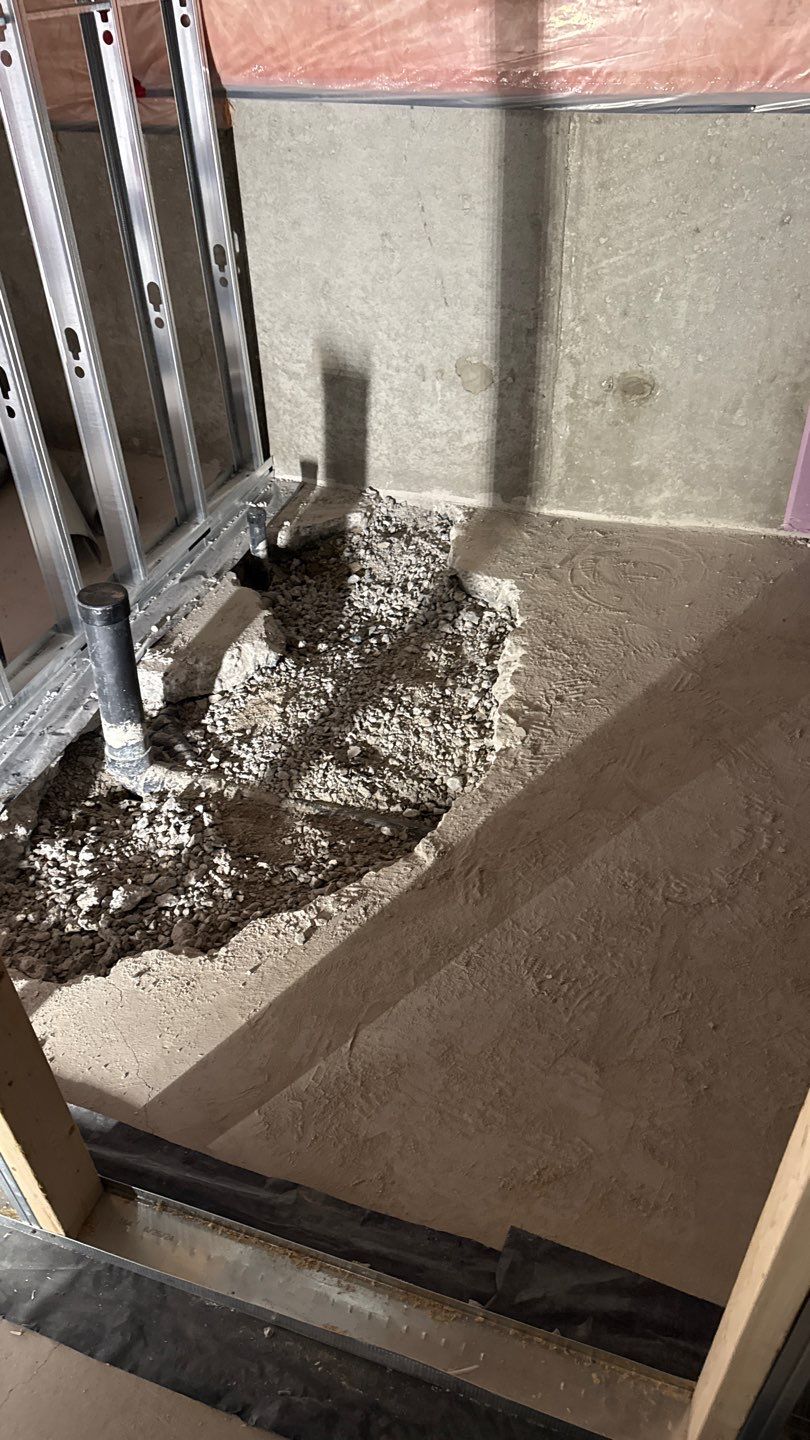 Concrete basement floor broken up to run drains for a new bathroom