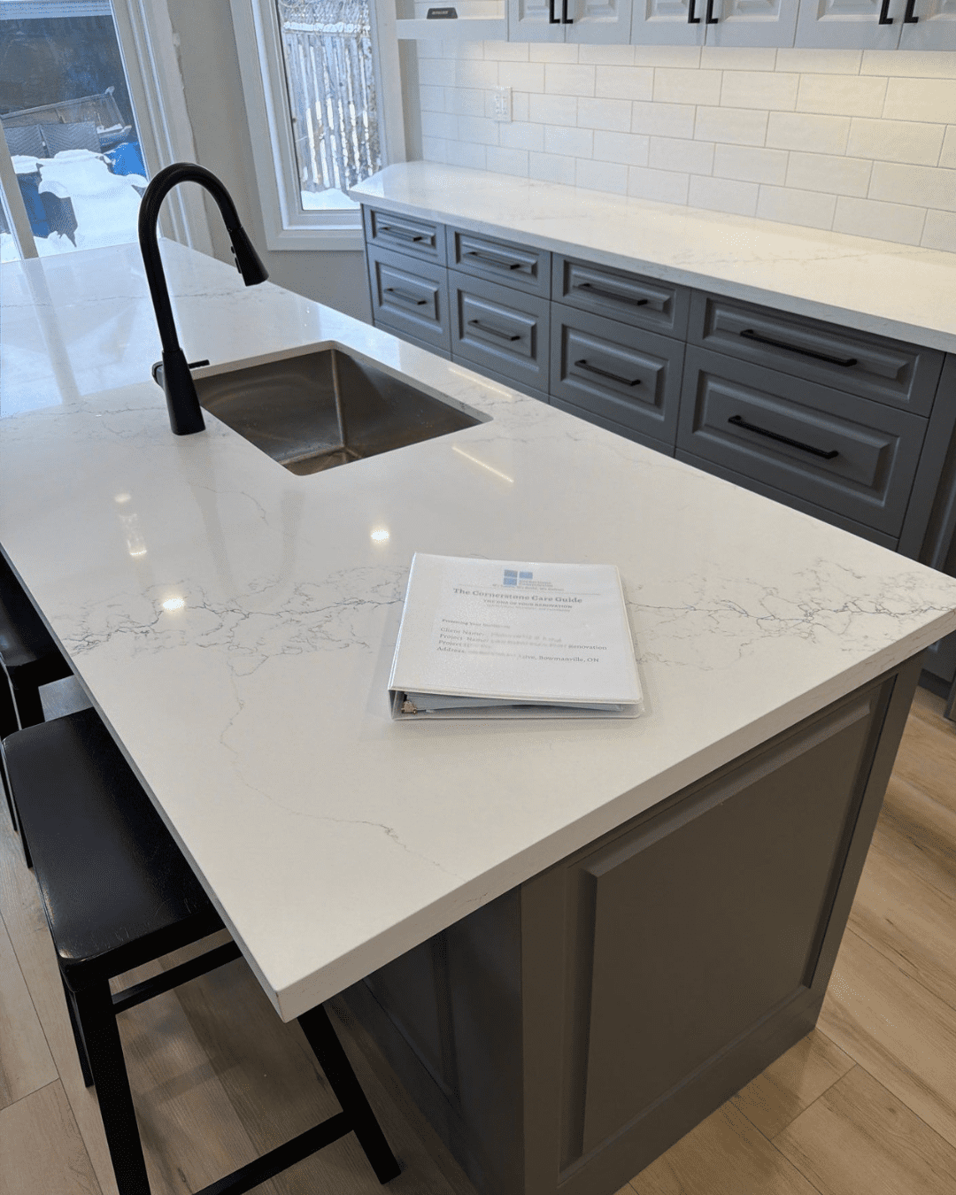 The Cornerstone Care Guide Owner's Manual on the finished quartz island