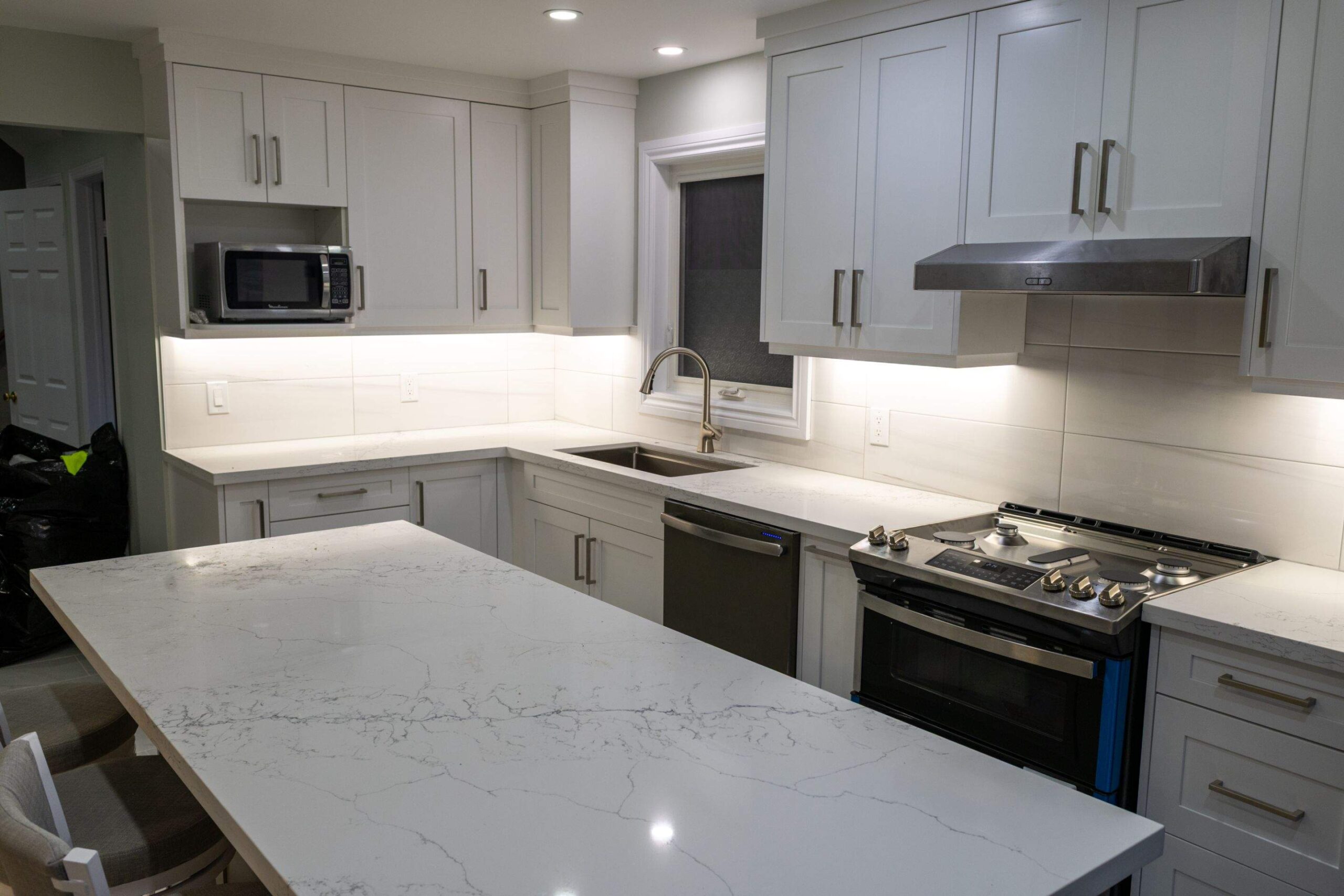 Open-concept kitchen renovation in Pickering with island and quartz counters